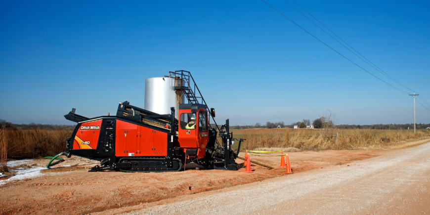 Directional drilling equipment installing utilities beneath active transportation infrastructure.