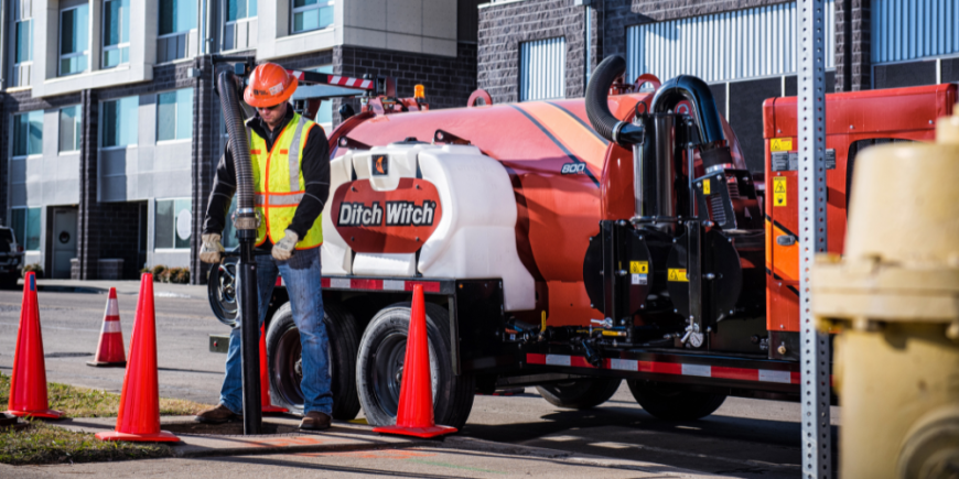 Technicians using Ditch Witch extractor equipment to safely expose underground sewer lines.